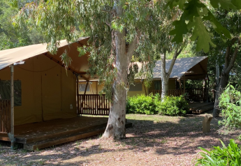 Safari-telt på Campo dei Fiori (Glamping4all) i Italien med veranda, træer og grøn natur omkring.