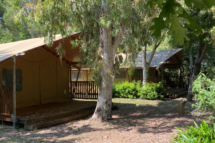 Safari tent at Campo dei Fiori (Glamping4all) in Italy, set among trees and lush greenery in nature.