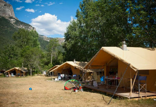 Safari tents at Huttopia Vallouise holiday park in Provence-Alpes-Côte d’Azur, France, set among mountains.