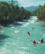 Piragüistas remando en un río turquesa rodeado de árboles cerca de Vallouise, en la región francesa de Provenza.