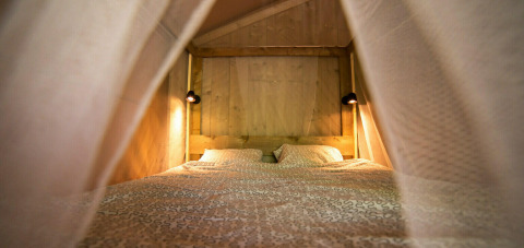 Interior view of a cozy sleeping area inside a Safari Lodge tent at Camping Centro Vacanze San Marino.