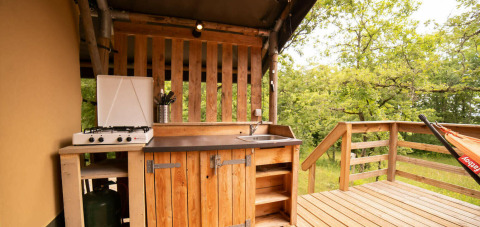 Cucina esterna della tenda Safari Lodge al Camping Centro Vacanze San Marino, immersa nel verde.