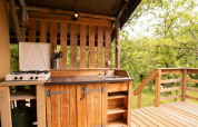 Cuisine extérieure d'une tente Safari Lodge au Camping Centro Vacanze San Marino, entourée de verdure.