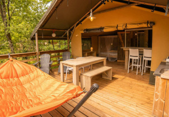 Safari Lodge tent aan Camping Centro Vacanze San Marino met houten terras, oranje hangmat en eethoek.