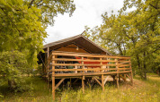 Tenda Safari Lodge al Camping Centro Vacanze San Marino, immersa tra alberi e natura rigogliosa.