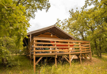 Tenda Safari Lodge al Camping Centro Vacanze San Marino, immersa tra alberi e natura rigogliosa.