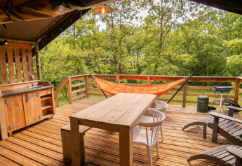 Houten terras met hangmat, buitenkeuken en stoelen aan de Safari Lodge, Camping San Marino.