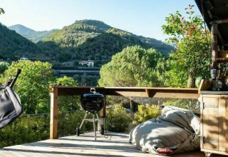 Terrazza all’aperto a Isolabona, Liguria, con vista monti, barbecue, poltrona sospesa e comodi pouf.
