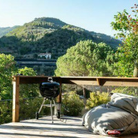 Outdoor terrace in Isolabona, Liguria, Italy, offering mountain views, a grill, hammock chair, and bean bags.