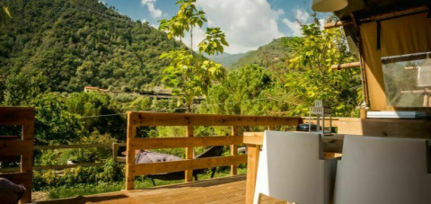 Vista dalla terrazza al Camping Delle Rose in Liguria, Italia, circondata da colline e verde lussureggiante.
