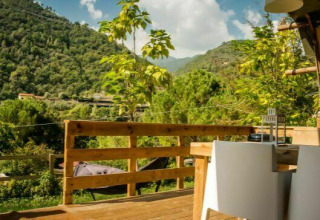 Vista dalla terrazza al Camping Delle Rose in Liguria, Italia, circondata da colline e verde lussureggiante.