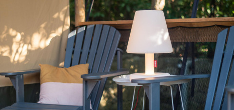 Buiten zithoek met twee stoelen, kussens en een lamp bij Safari Lodge tent op Camping Delle Rose, Italië.