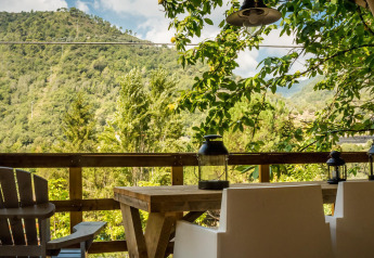 Vue depuis la tente safari Base Lodge au Camping Delle Rose en Italie, avec sièges, table et montagnes.