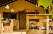 Tenda safari Desert Lodge al Camping Delle Rose in Italia con terrazza in legno e area salotto esterna.