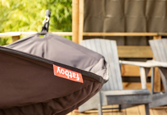 Close-up van een Fatboy hangmat en twee houten stoelen op het terras van de Wood Lodge safaritent, Camping Delle Rose.