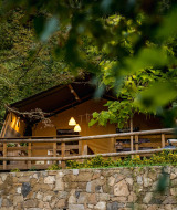 Tienda de glamping en Camping Delle Rose, Liguria, Italia, rodeada de frondoso bosque y naturaleza viva.