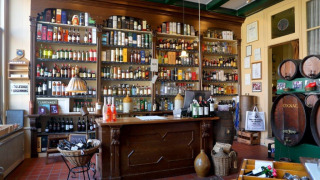 Vista del bar tradicional en Camping Vrijhaven Heeg, con estanterías llenas de botellas y barriles antiguos.