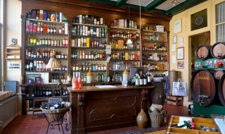 Vista del bar tradicional en Camping Vrijhaven Heeg, con estanterías llenas de botellas y barriles antiguos.