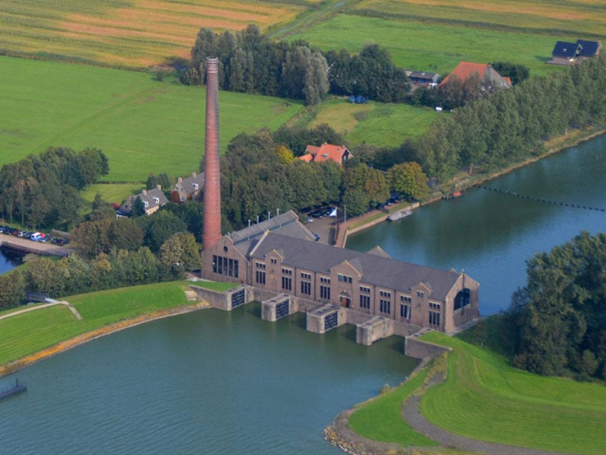 Aerial view of Camping Vrijhaven Heeg holiday park in Friesland, Netherlands, beside the water and fields.