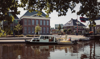 Foto de puerto en un parque vacacional con glamping, barcos atracados frente a edificios tradicionales.