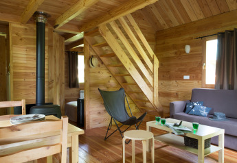Interieur van het houten chalet bij Les Chalets Huttopia de Font-Romeu in Frankrijk met gezellige zithoek.