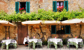 Acogedor restaurante al aire libre cerca de Rosignano Marittimo, Toscana, Italia, con muros de piedra y enredaderas.