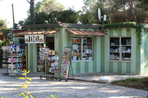 Pequeña tienda en el parque vacacional Campo dei Fiori en Toscana, Italia, con prensa y recuerdos.