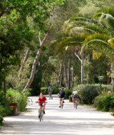 Cyclists ride along a tree-lined path at Campo dei Fiori holiday park in Tuscany, Italy.