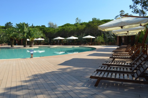 Poolside lounge chairs and umbrellas at Campo dei Fiori Glamping4all holiday park in Tuscany, Italy.