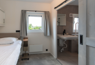 Barrierefreies Zimmer mit Einzelbett und Bad, Access Lodge, Kompas Camping - Westende, Belgien.