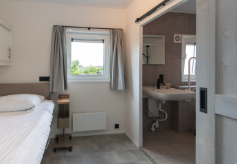 Habitación accesible con cama individual y baño privado, Access Lodge, Kompas Camping - Westende, Bélgica.