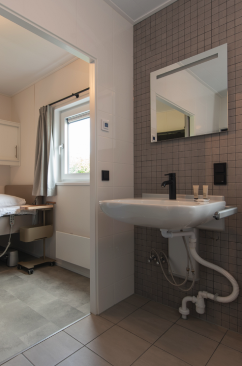 Badeværelse med håndvask og spejl på Access Lodge ved Kompas Camping - Westende i Belgien.
