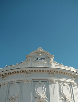 Fachada de un edificio de casino blanco e histórico bajo un cielo azul claro cerca de Moyaux, Normandía, Francia.