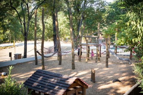 Parque infantil con estructuras de madera y tobogán en Huttopia le Moulin, Auvergne-Rhône-Alpes, Francia.