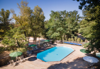 Buitenzwembad met houten terras in vakantiepark Huttopia le Moulin, Auvergne-Rhône-Alpes, Frankrijk.
