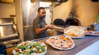 Un chef hornea pizzas en horno de leña en Huttopia le Moulin, un parque vacacional en Auvernia-Ródano-Alpes, Francia.