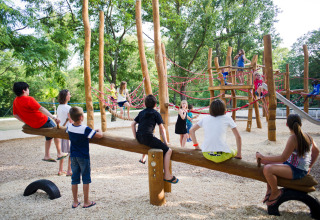 Kinderen amuseren zich op een houten speeltuin bij Huttopia le Moulin in Auvergne-Rhône-Alpes, Frankrijk.