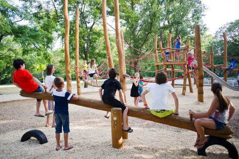Bambini giocano in un parco giochi in legno a Huttopia le Moulin, Auvergne-Rhône-Alpes, Francia.