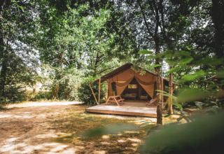 Tenda safari immersa nel bosco presso Huttopia Vallée du Lot, parco vacanze in Nouvelle-Aquitaine, Francia.