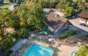 Luftfoto af Huttopia Divonne Les Bains feriepark i Auvergne-Rhône-Alpes med pool og grønne omgivelser.