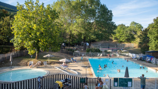 Piscina al aire libre y piscina infantil en medio de árboles en Huttopia Divonne Les Bains, Francia.