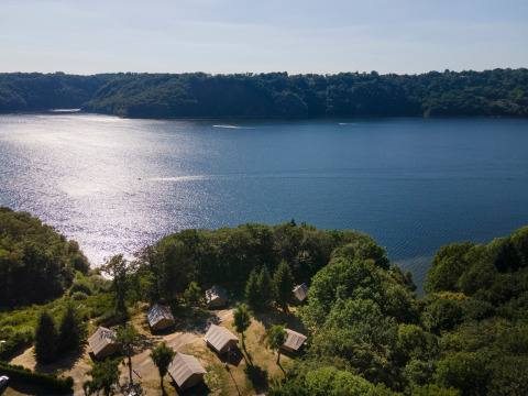 Vista aérea del parque vacacional Huttopia Lac de la Siauve junto al lago y bosque en Auvernia-Ródano-Alpes, Francia.