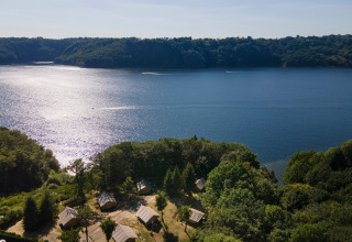 Luchtfoto van vakantiepark Huttopia Lac de la Siauve aan het meer, omlijst door bos in Auvergne-Rhône-Alpes, Frankrijk.