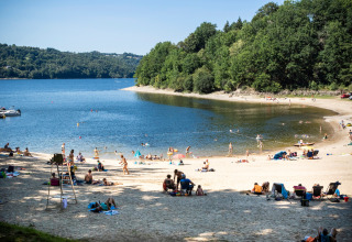 Mensen ontspannen op het strand in vakantiepark Huttopia Lac de la Siauve in Auvergne-Rhône-Alpes, Frankrijk.