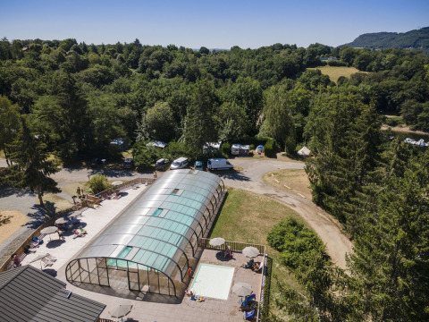 Vista aérea de Huttopia Lac de la Siauve, parque vacacional en Auvergne-Rhône-Alpes, Francia, con piscina cubierta.