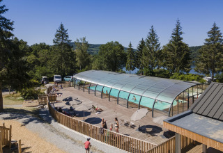 Overdekt zwembad met zonneterras bij Huttopia Lac de la Siauve, vakantiepark in Auvergne-Rhône-Alpes, Frankrijk.