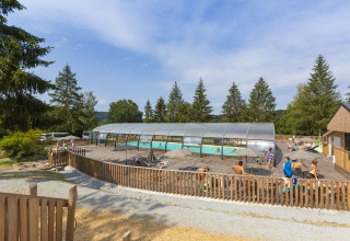 Overdekt zwembad met ontspannen vakantiegangers in een vakantiepark in Auvergne-Rhône-Alpes, Frankrijk.