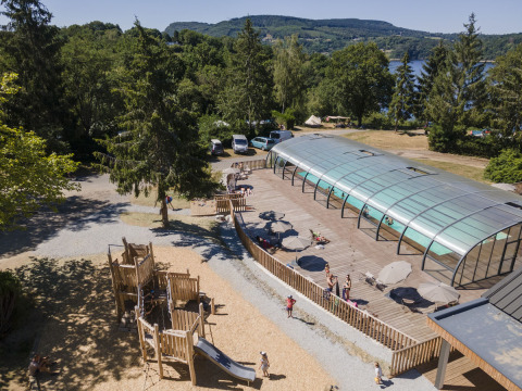 Aire de jeux et piscine couverte au parc de vacances Huttopia Lac de la Siauve en Auvergne-Rhône-Alpes, France.