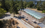 Spielplatz und überdachtes Schwimmbad im Ferienpark Huttopia Lac de la Siauve in Auvergne-Rhône-Alpes, Frankreich.