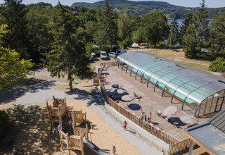 Aire de jeux et piscine couverte au parc de vacances Huttopia Lac de la Siauve en Auvergne-Rhône-Alpes, France.